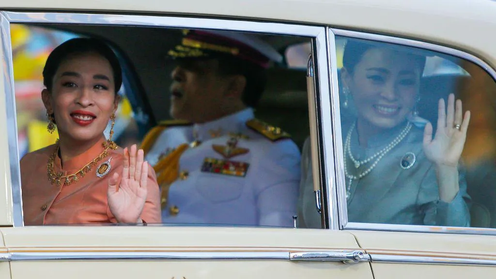 Princess Bajrakitiyabha waves to the crowd while riding a car with her father, King Vajiralongkorn and Queen Suthida. / PHOTO FILE Getty Images