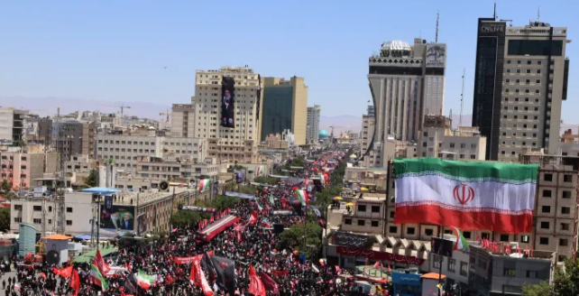 Visible in the foreground is a large Iranian national flag prominently displayed / Photo Aljazeera